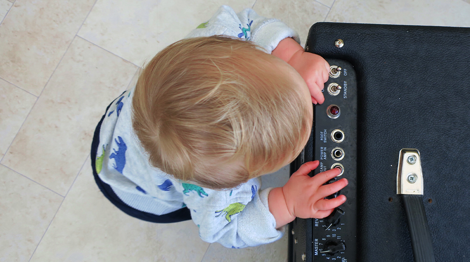 Baby next to guitar amplifier