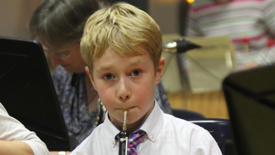 A young boy plays the Oboe