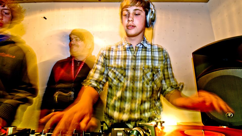 A young DJ mixes on vinyl decks