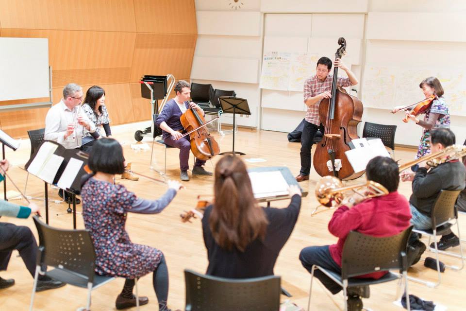 Orchestral musicians perform as a group in a workshop